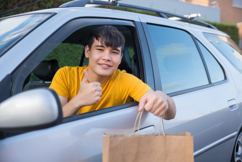 asian man with a yellow shirt delivering food