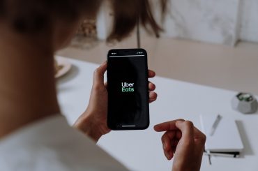 person holding phone with uber eats app
