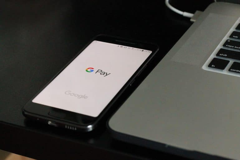 mobile phone displaying google login near laptop