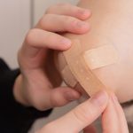 person putting on bandaid