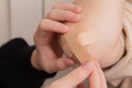 person putting on bandaid