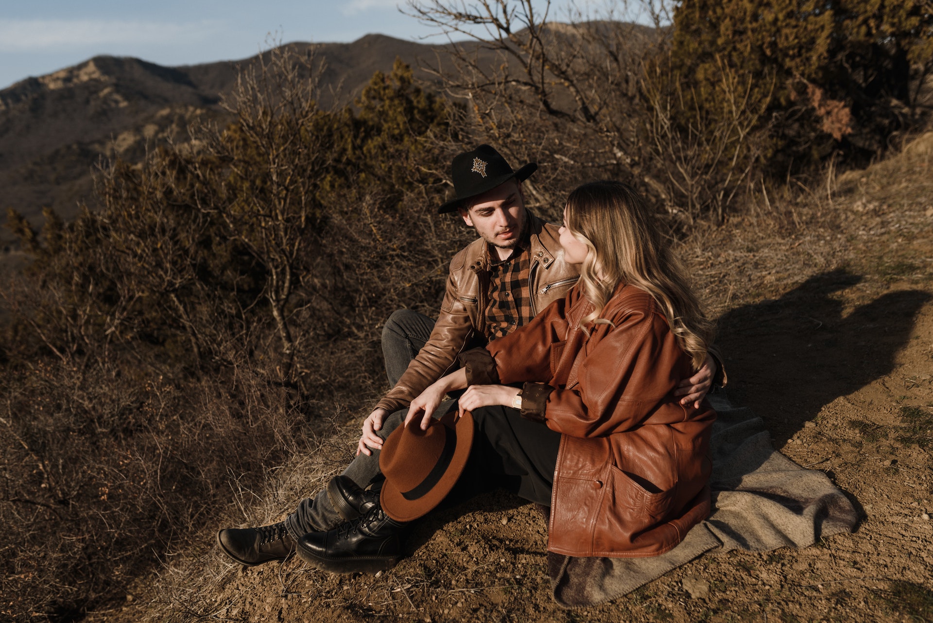 a couple sitting on a brown hill