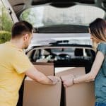 couple putting away boxes in new financed car