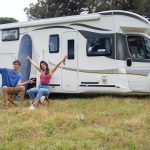 couple sitting in front of RV