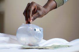 woman depositing savings into a piggy bank
