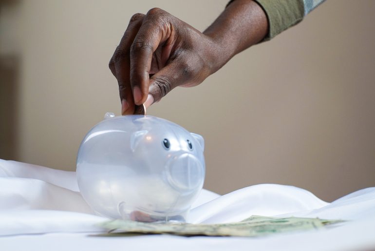 woman depositing savings into a piggy bank